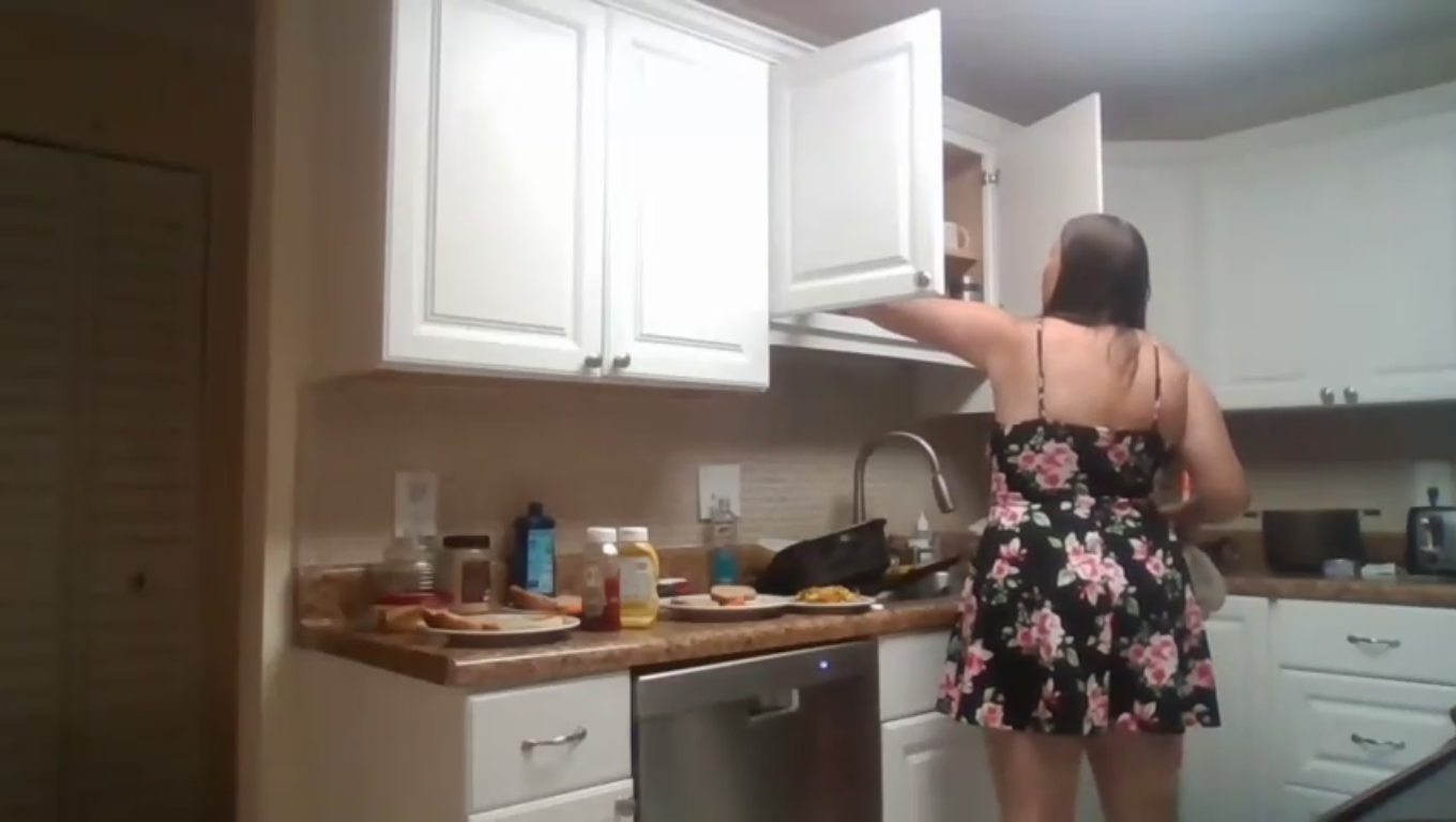 reaching into the kitchen cabinet